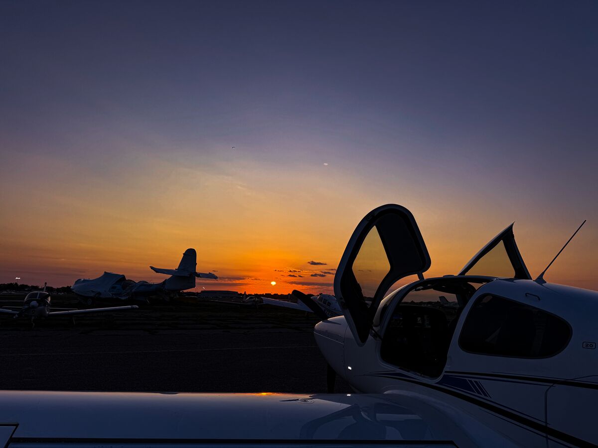 Airplane silhouette at sunset on tarmac